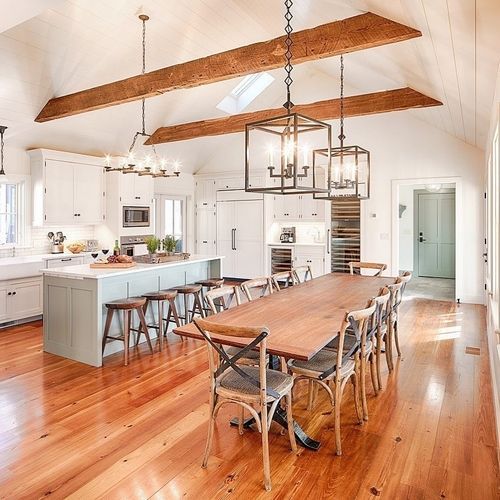 A kitchen with a long wooden table and chairs.