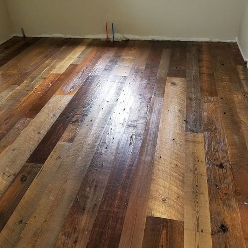A room with a wooden floor and a white wall.