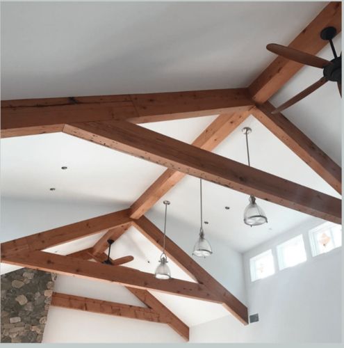 A ceiling with wooden beams and a ceiling fan