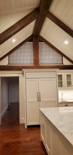 A kitchen with a vaulted ceiling and wooden beams.