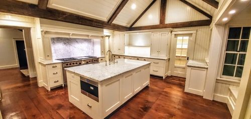 A kitchen with white cabinets and a large island in the middle.
