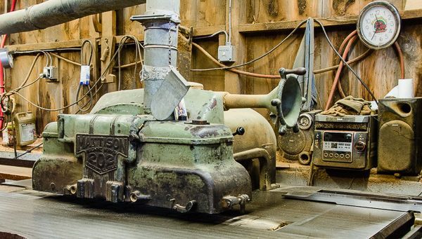 An old machine is sitting on a table in a workshop.