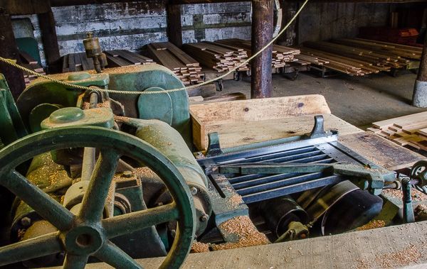 A green machine is sitting in a room with a lot of wood.