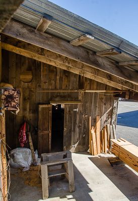 A wooden shed with a metal roof and a door.
