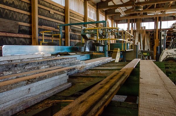 A warehouse filled with wooden boards and machinery.