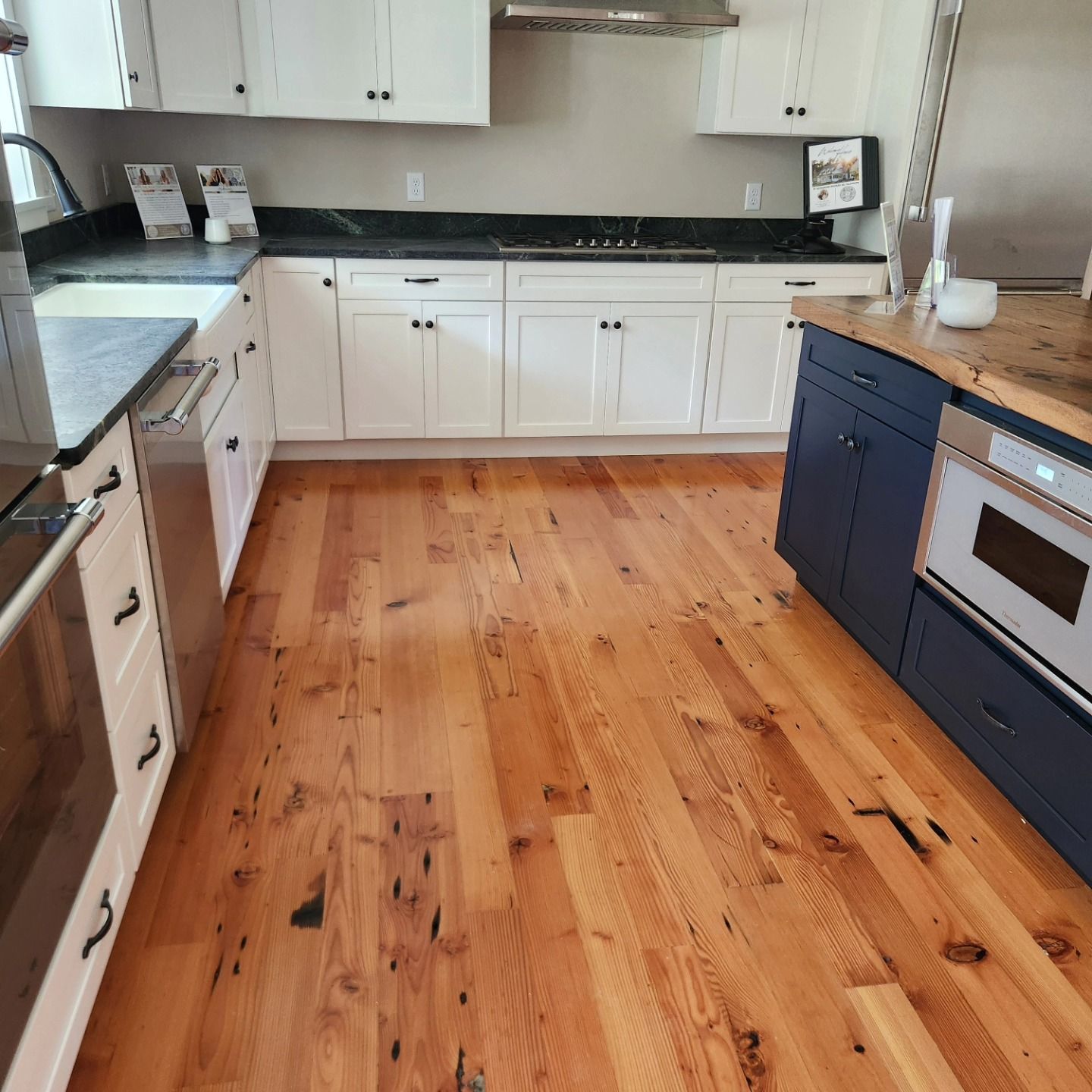 A kitchen with hardwood floors and white cabinets