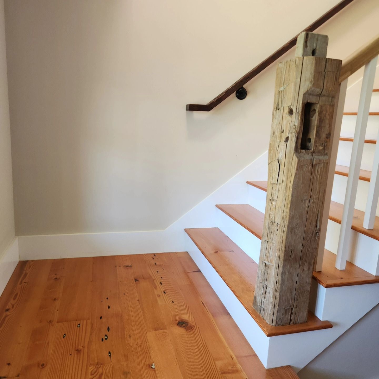 A wooden staircase with a wooden post in the middle