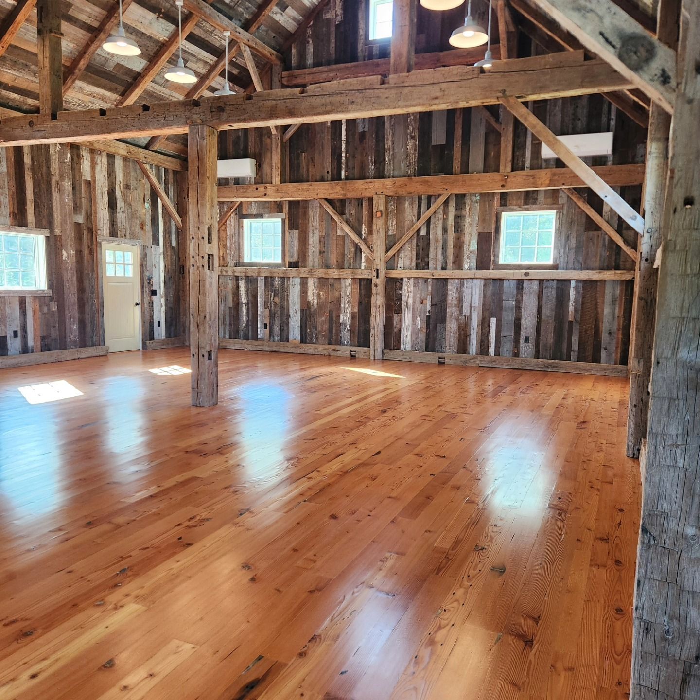 An empty barn with wooden floors and a white door