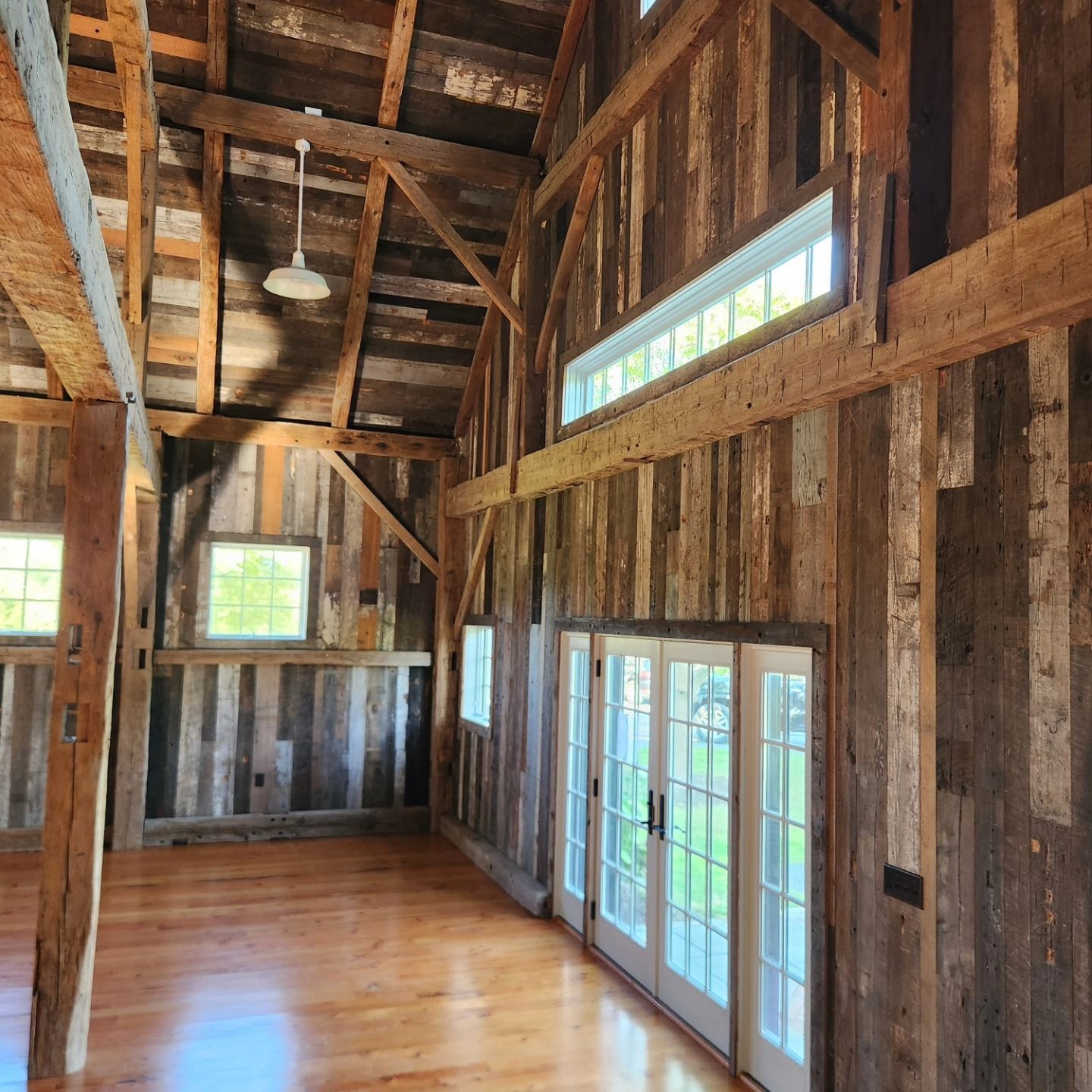 The inside of a barn with wooden beams and windows