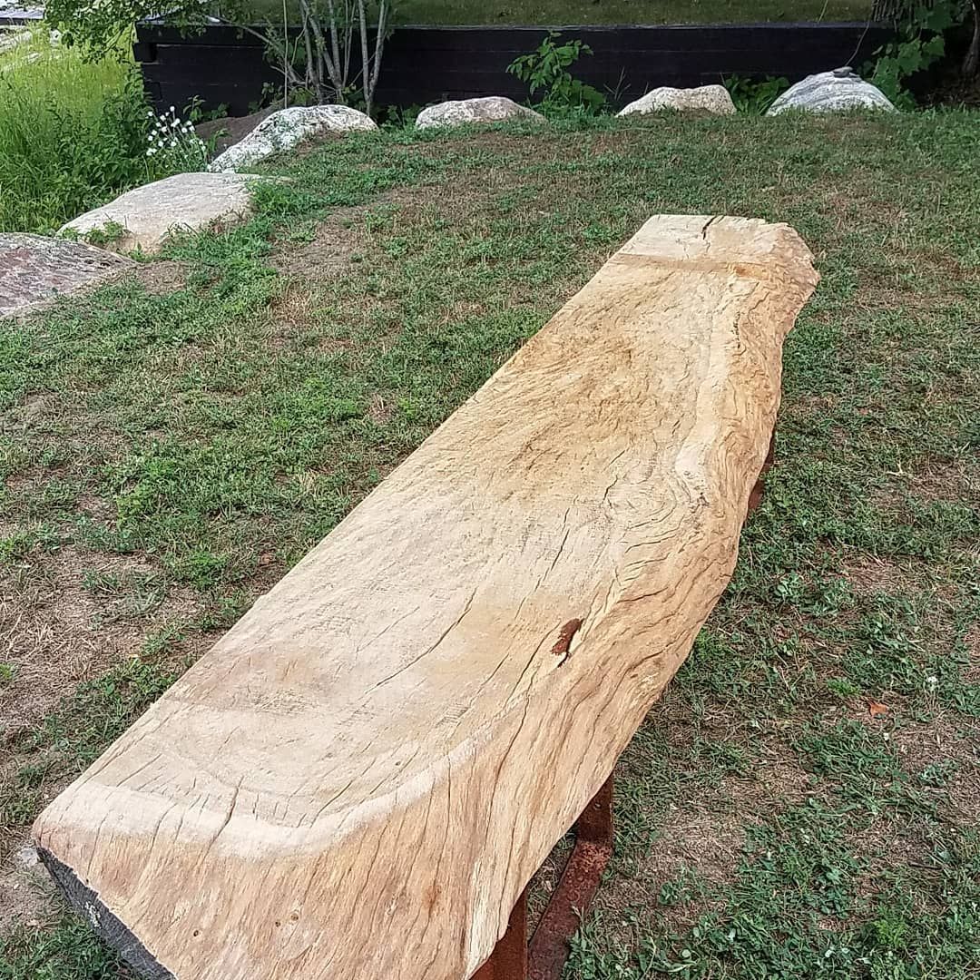 A wooden bench is sitting on top of a lush green field.