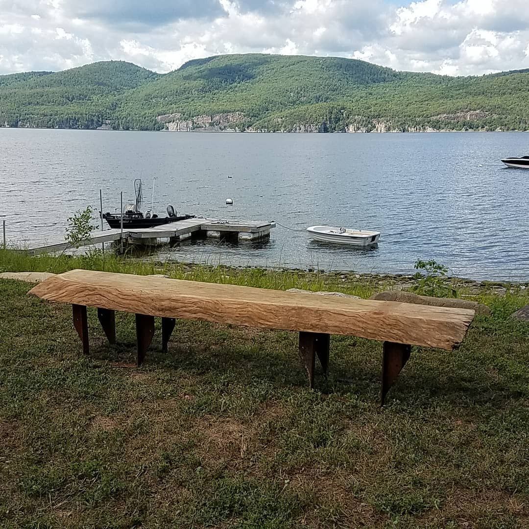 A wooden bench is sitting in the grass next to a lake.
