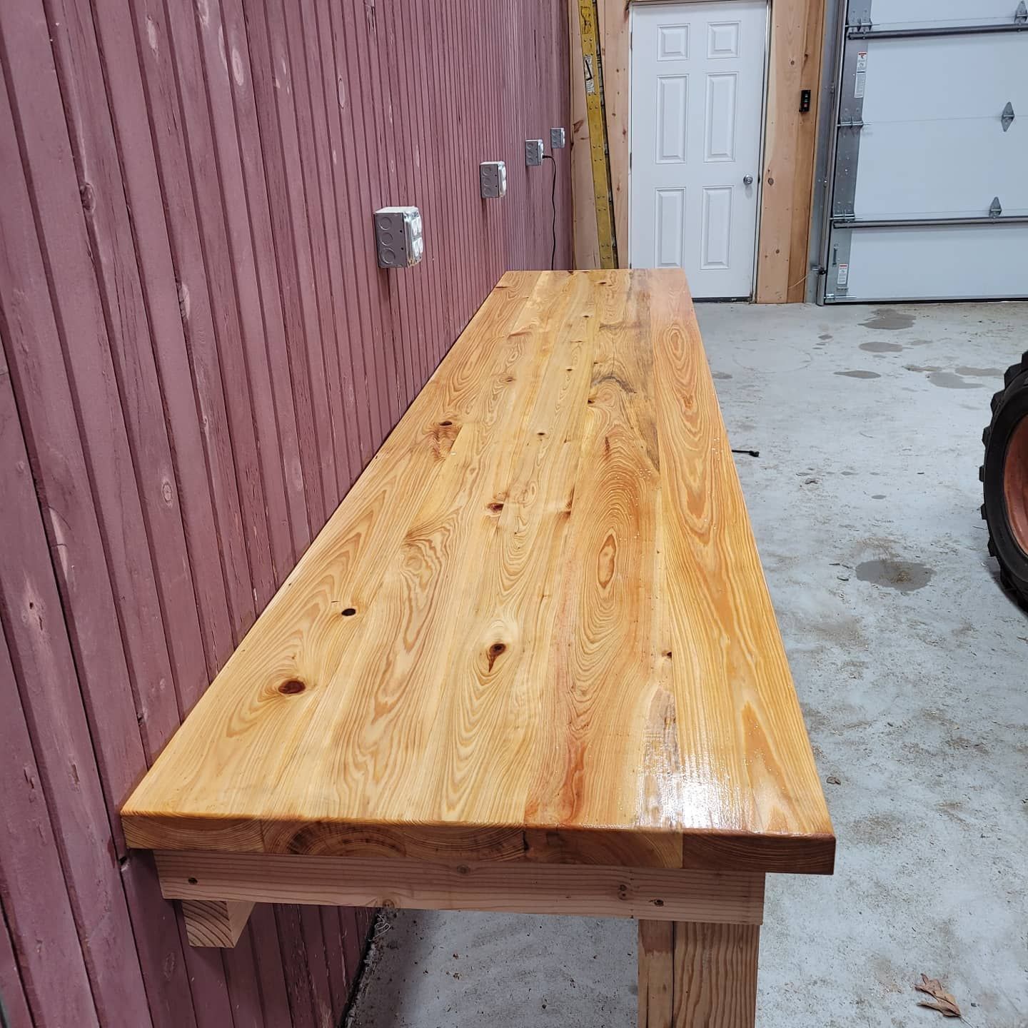 A wooden bench is sitting in front of a garage door