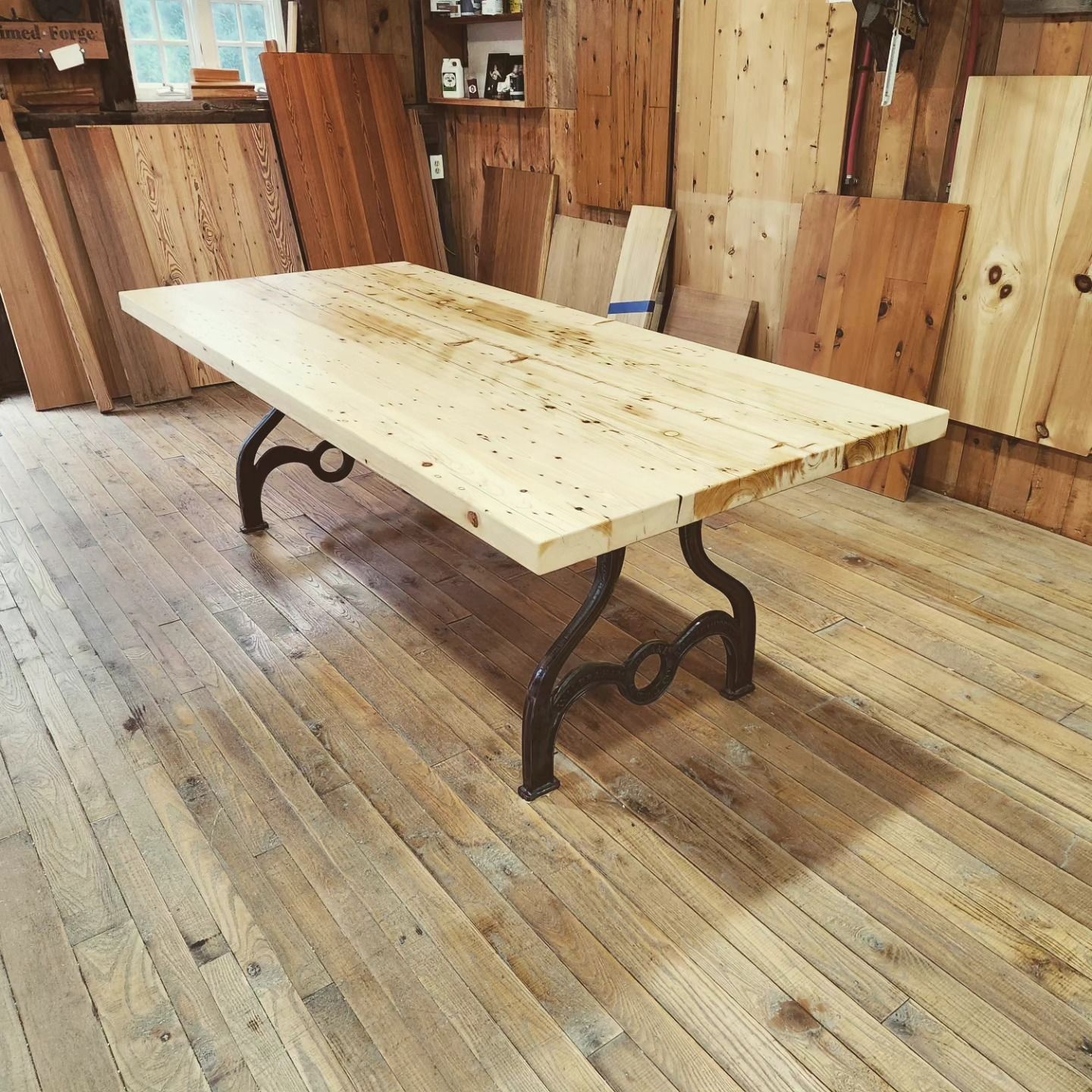 A wooden table with metal legs is sitting on a wooden floor