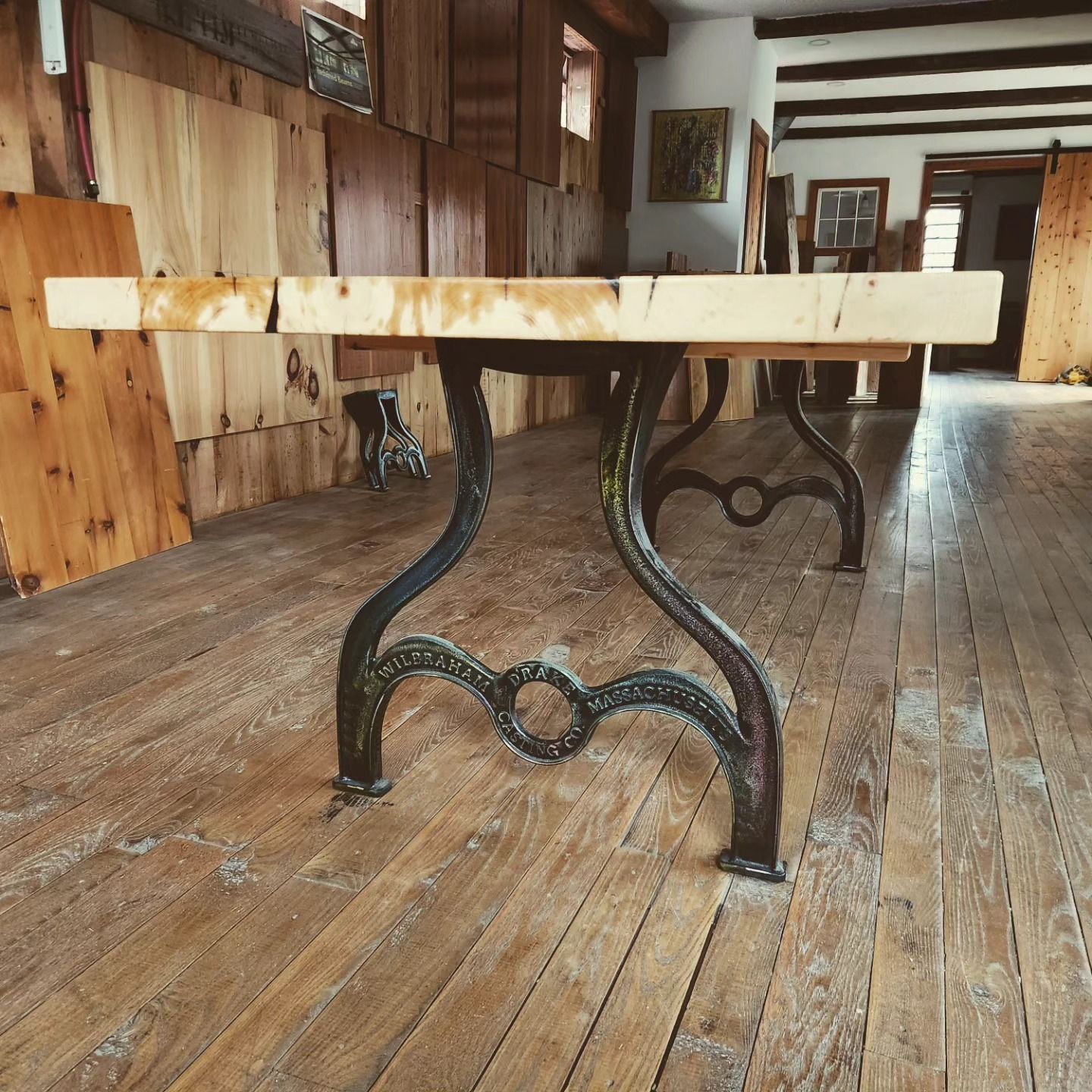 A wooden table with a metal base in a room