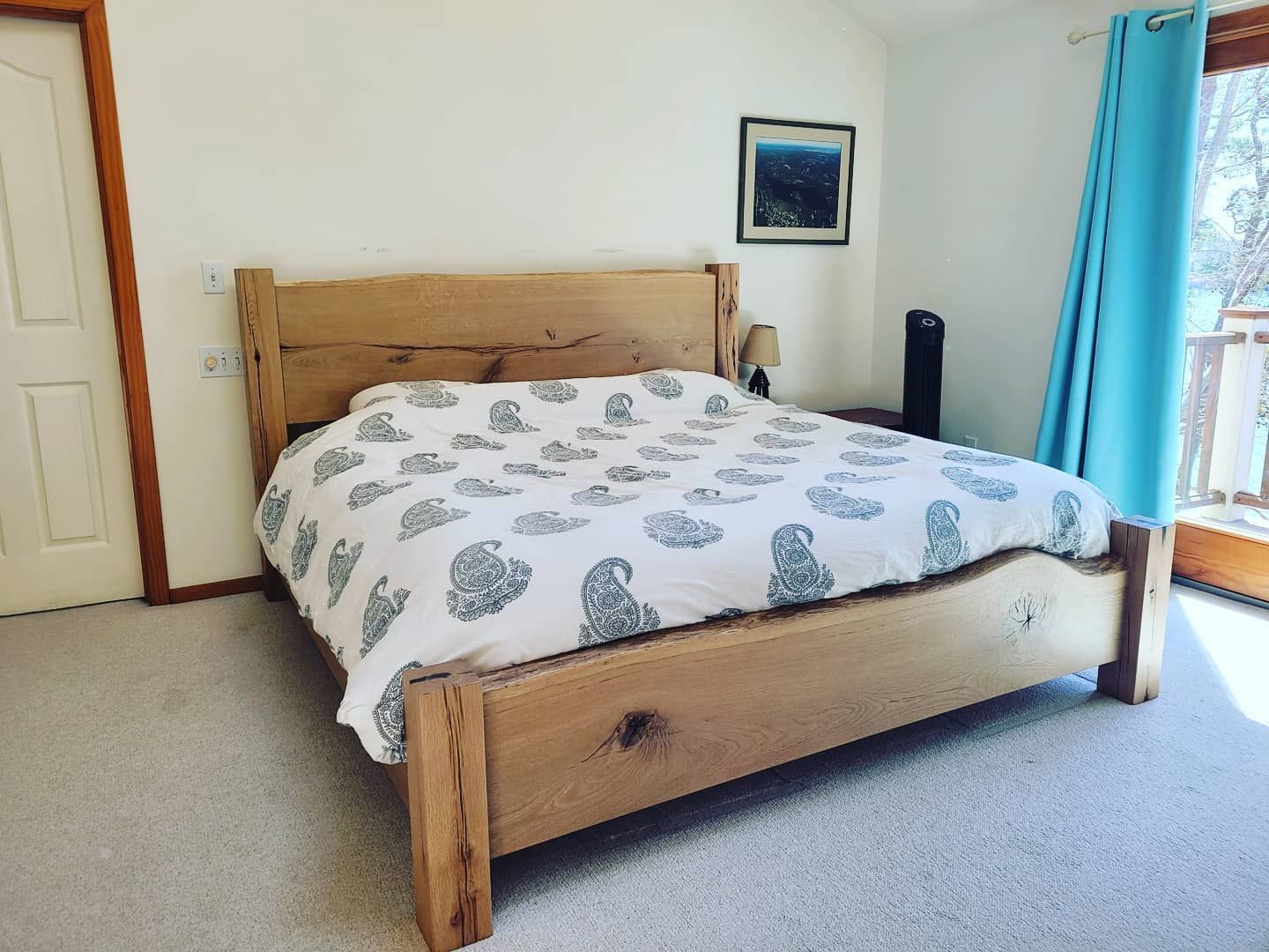A bedroom with a wooden bed and blue curtains