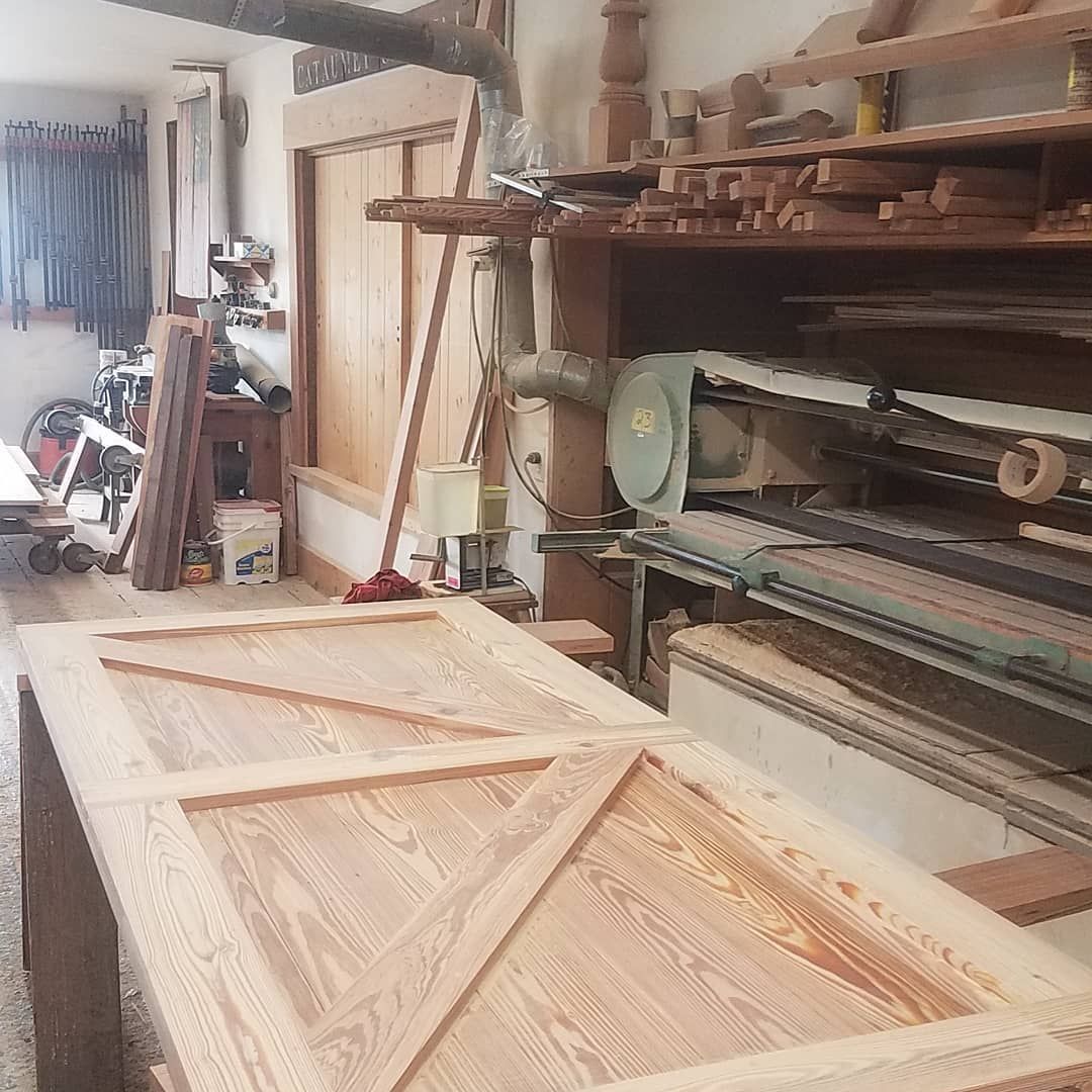 A wooden table is sitting in a room filled with wooden pieces.