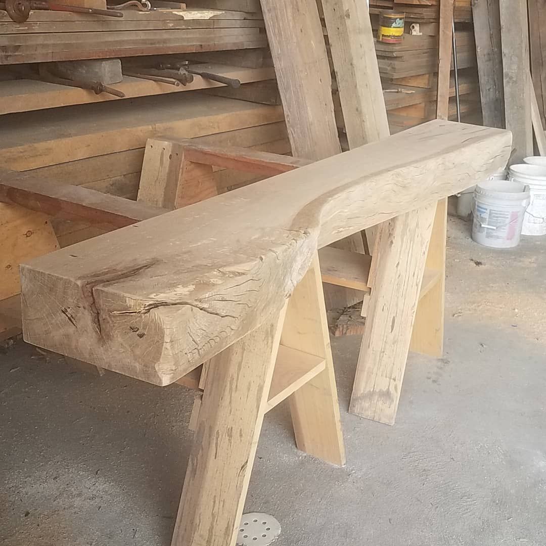 A piece of wood is sitting on top of a wooden bench.