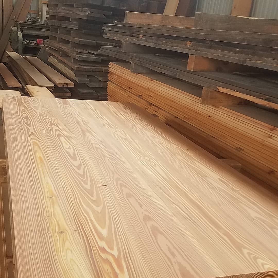 A pile of wooden boards sitting on top of each other in a warehouse.