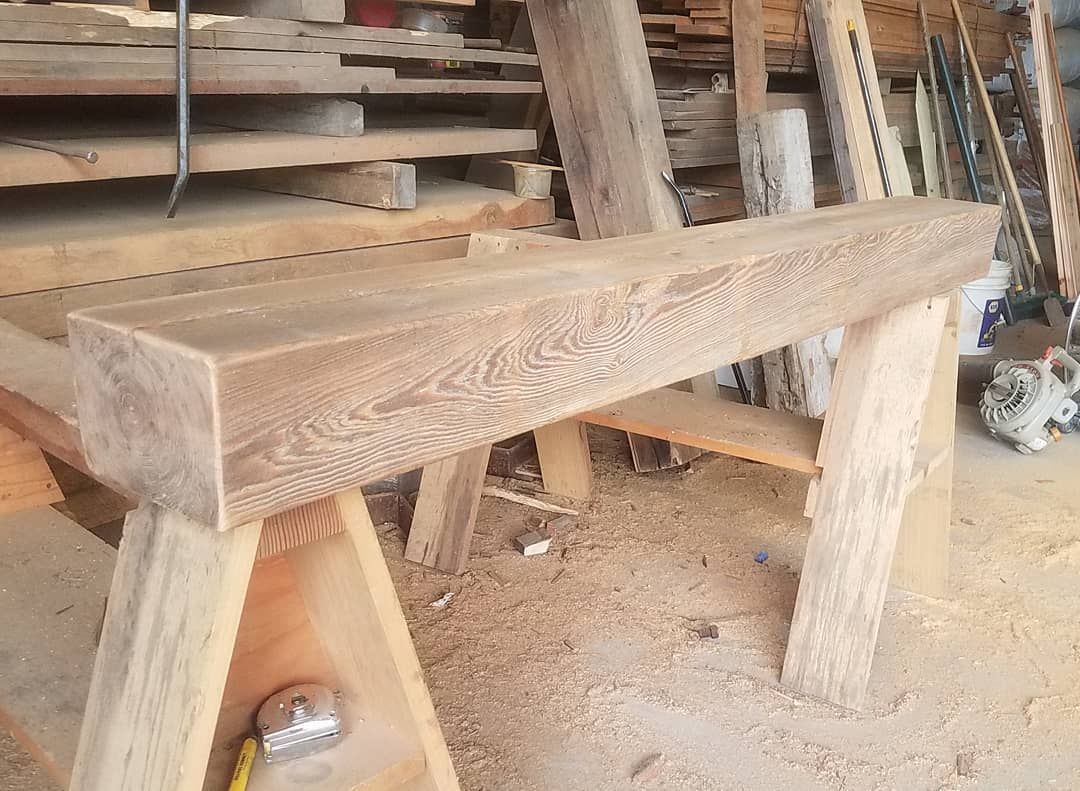 A wooden bench is sitting on top of a wooden trestle.