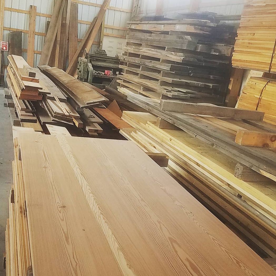 A warehouse filled with lots of wooden boards and pallets