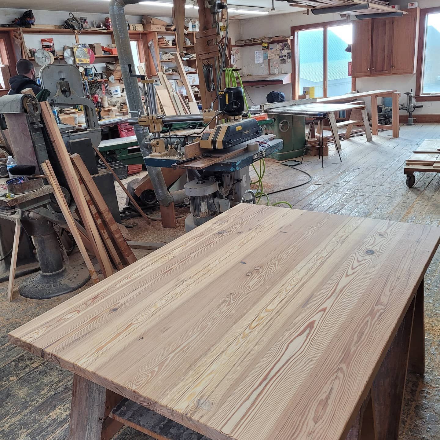 A wooden table is sitting in a woodworking shop.