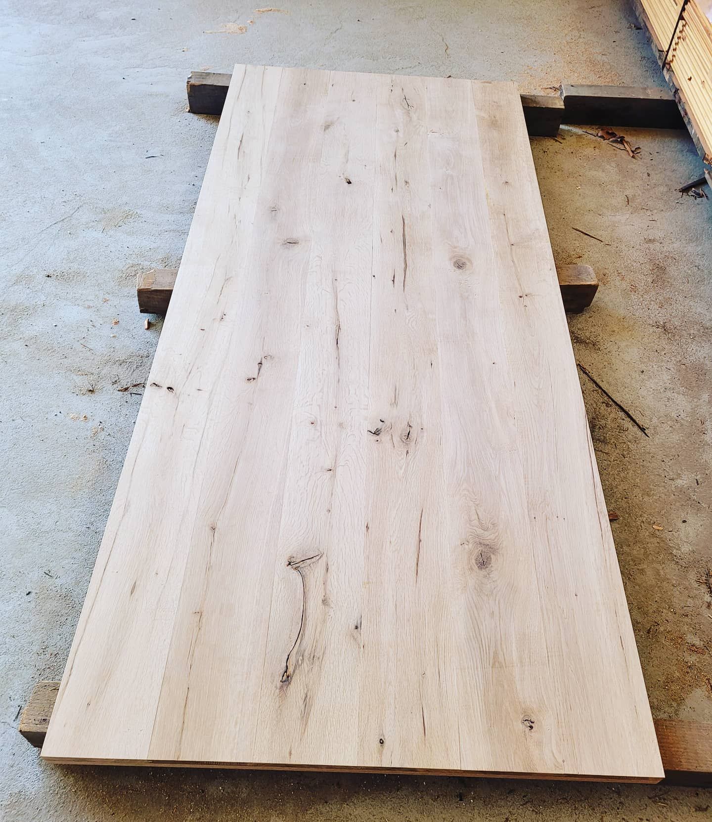 A large piece of wood is sitting on a concrete surface