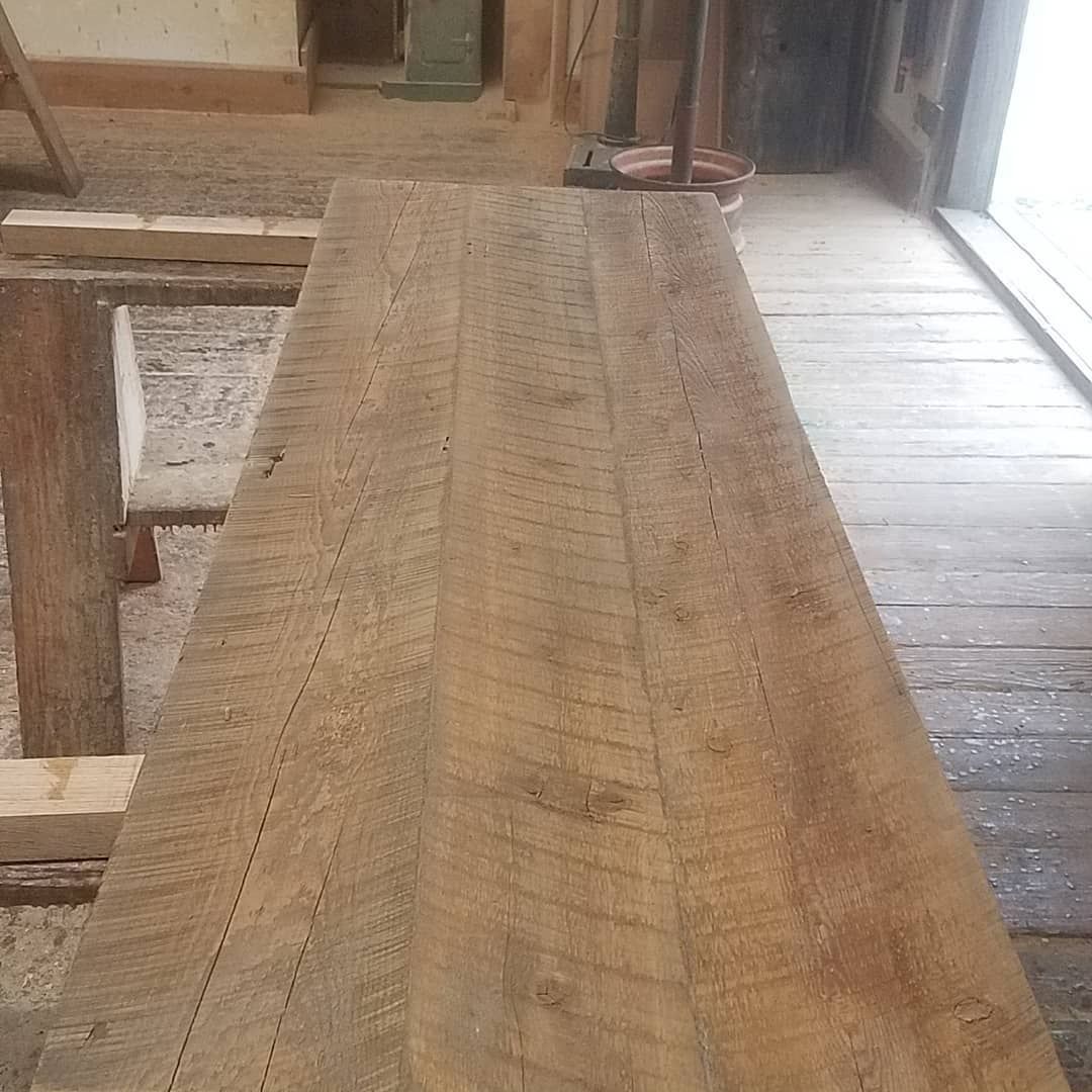 A wooden table is sitting on a wooden floor in a room.