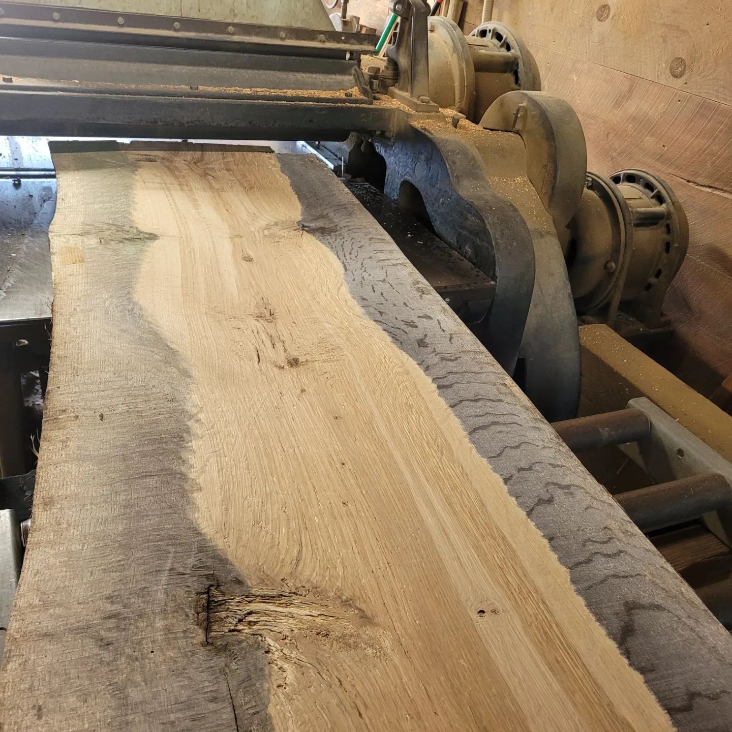A large piece of wood is being cut by a machine