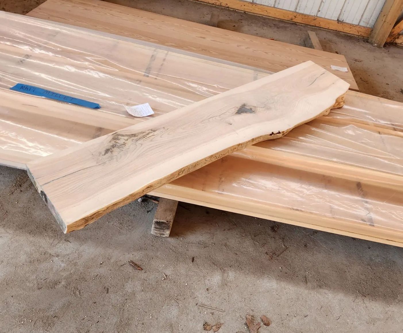 Two pieces of wood are laying on top of each other on the ground.