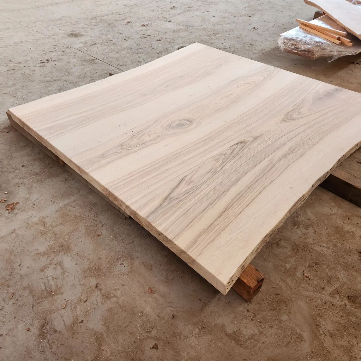 A square piece of wood is sitting on the ground