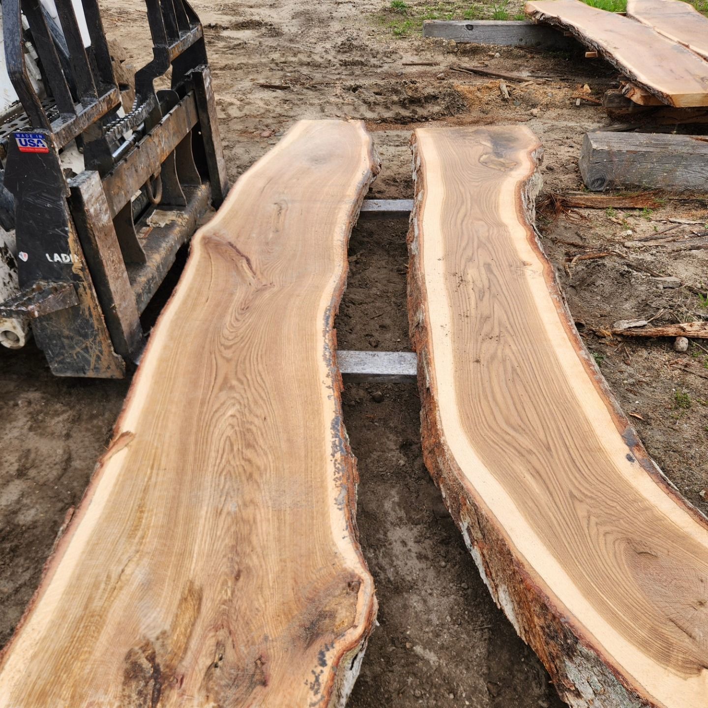 A forklift is carrying two pieces of wood