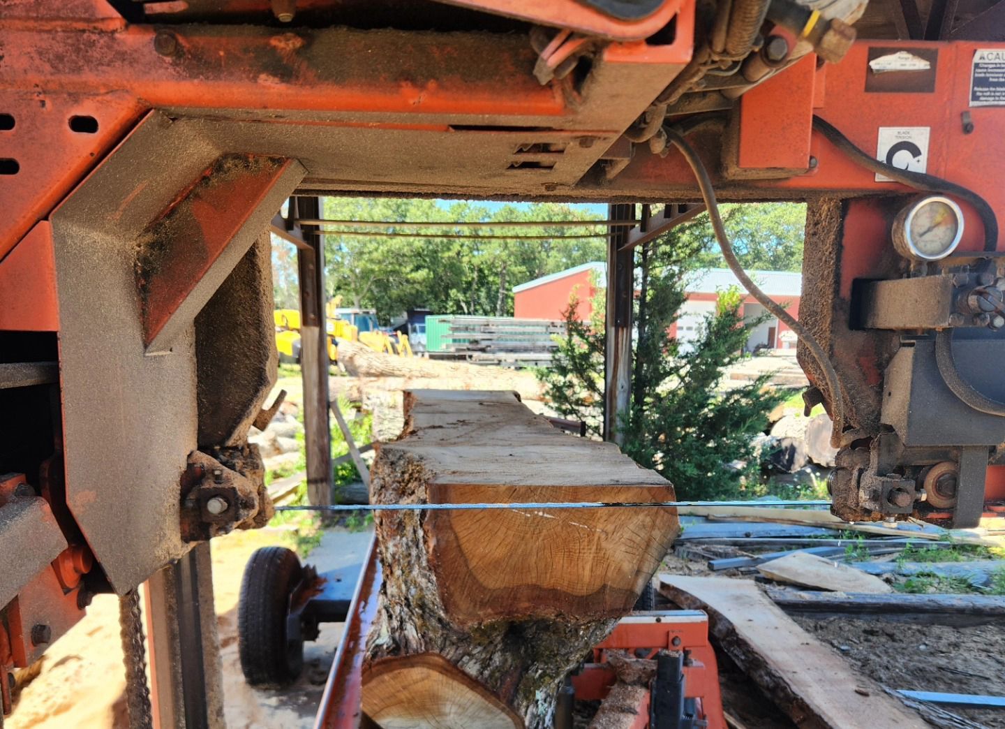 A large piece of wood is being cut by a machine with the letter c on it