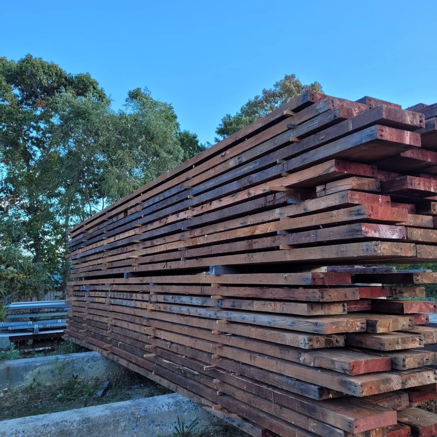 A stack of wooden boards with trees in the background