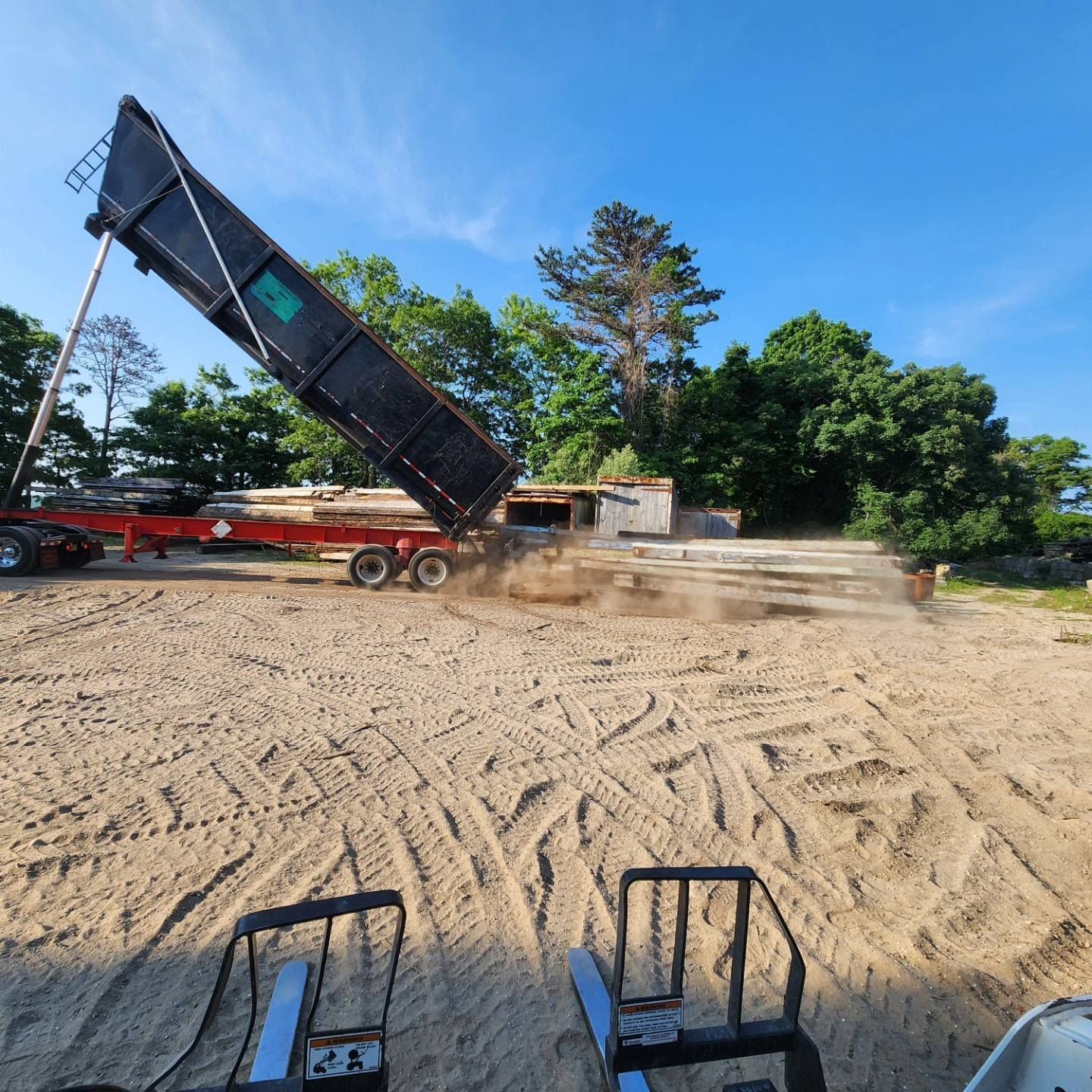 A dump truck is being loaded with dirt in a dirt field