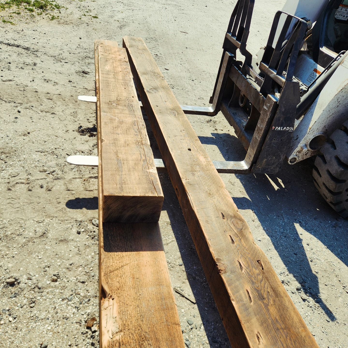 A forklift is carrying a large piece of wood