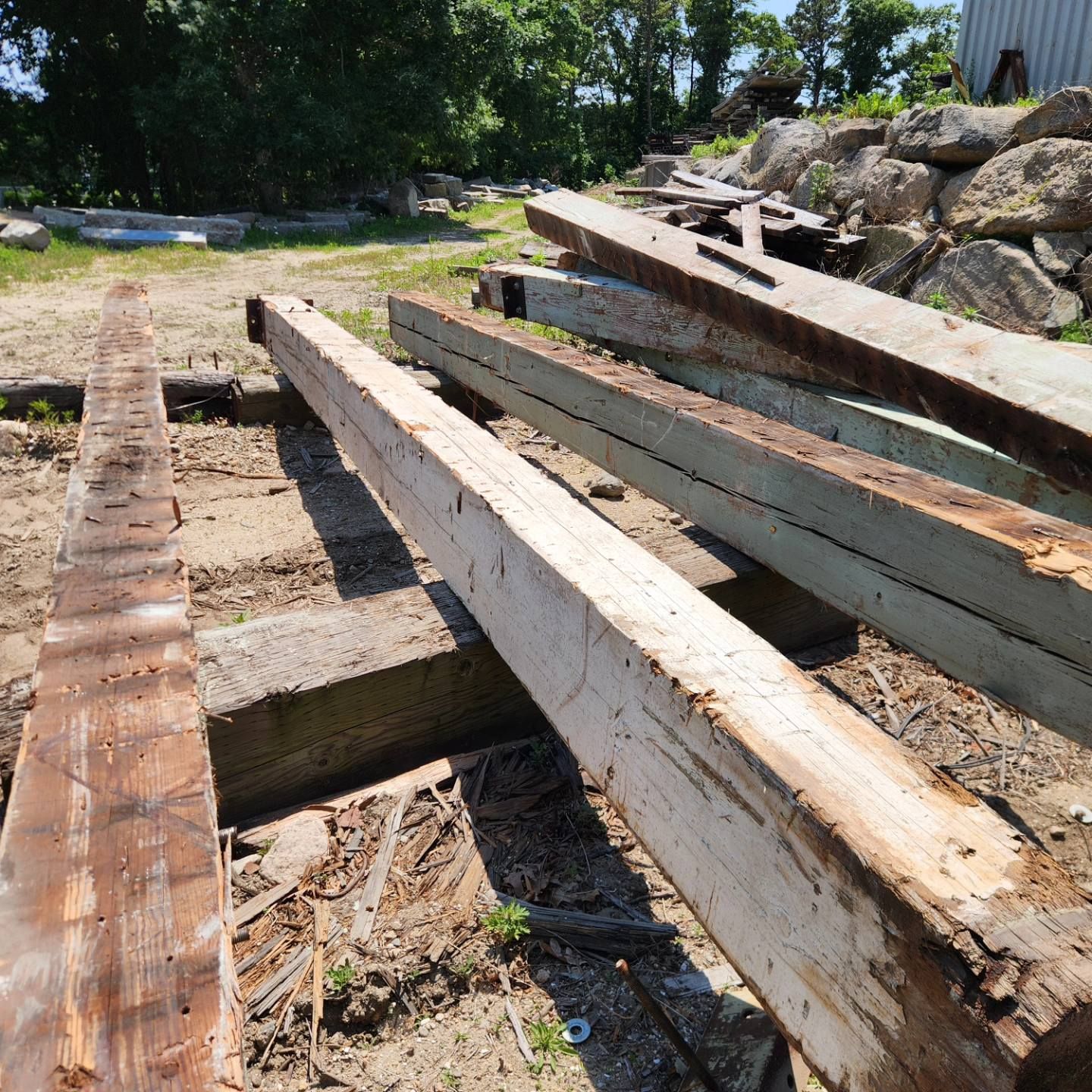 A bunch of wooden beams are laying on the ground