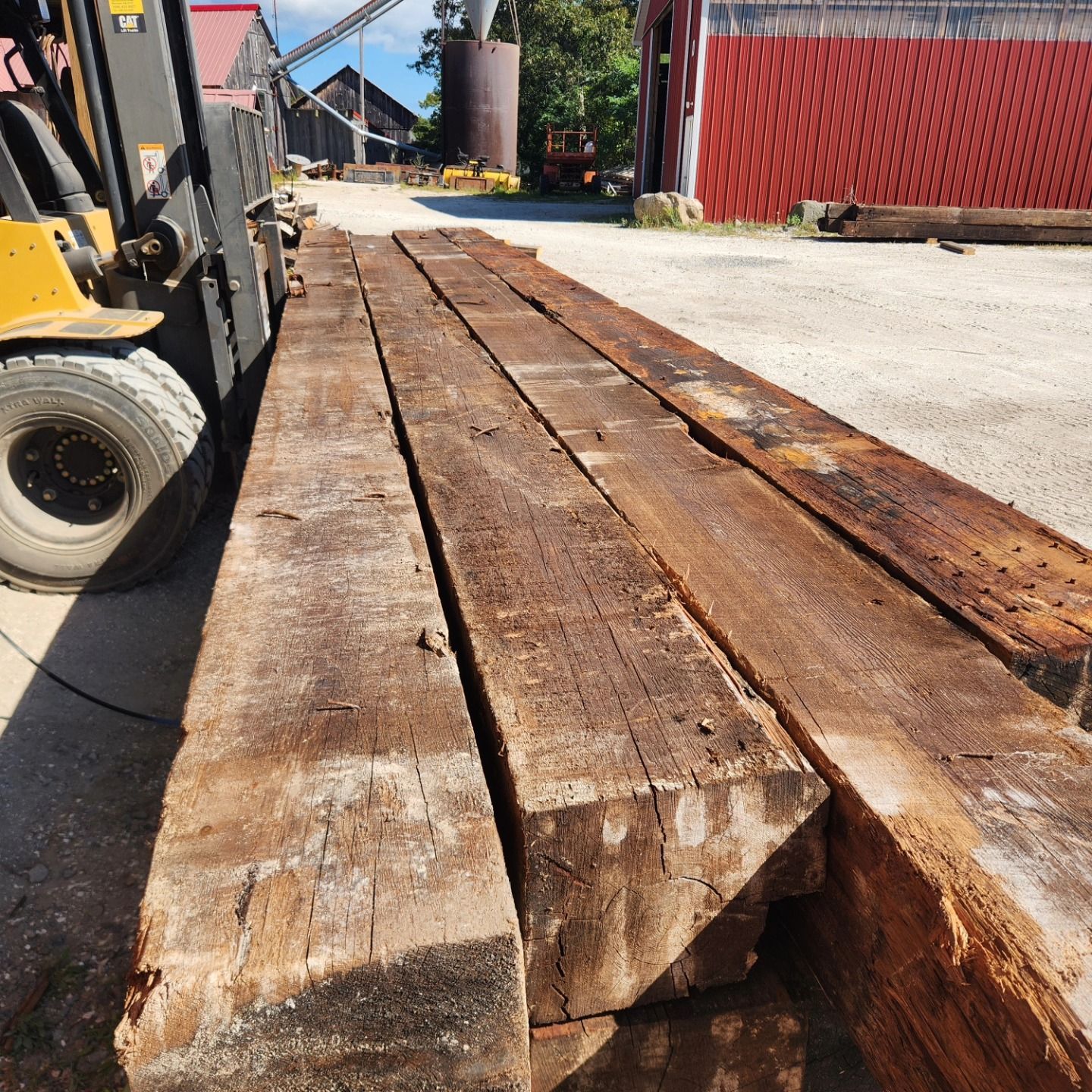 A forklift is carrying a stack of wooden beams