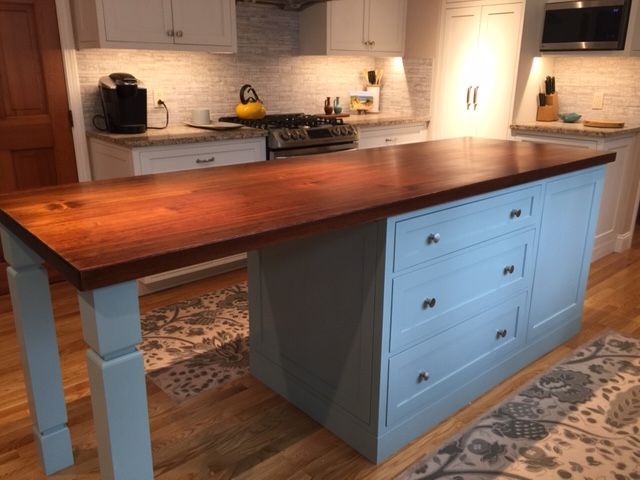 A kitchen with a wooden table and blue cabinets