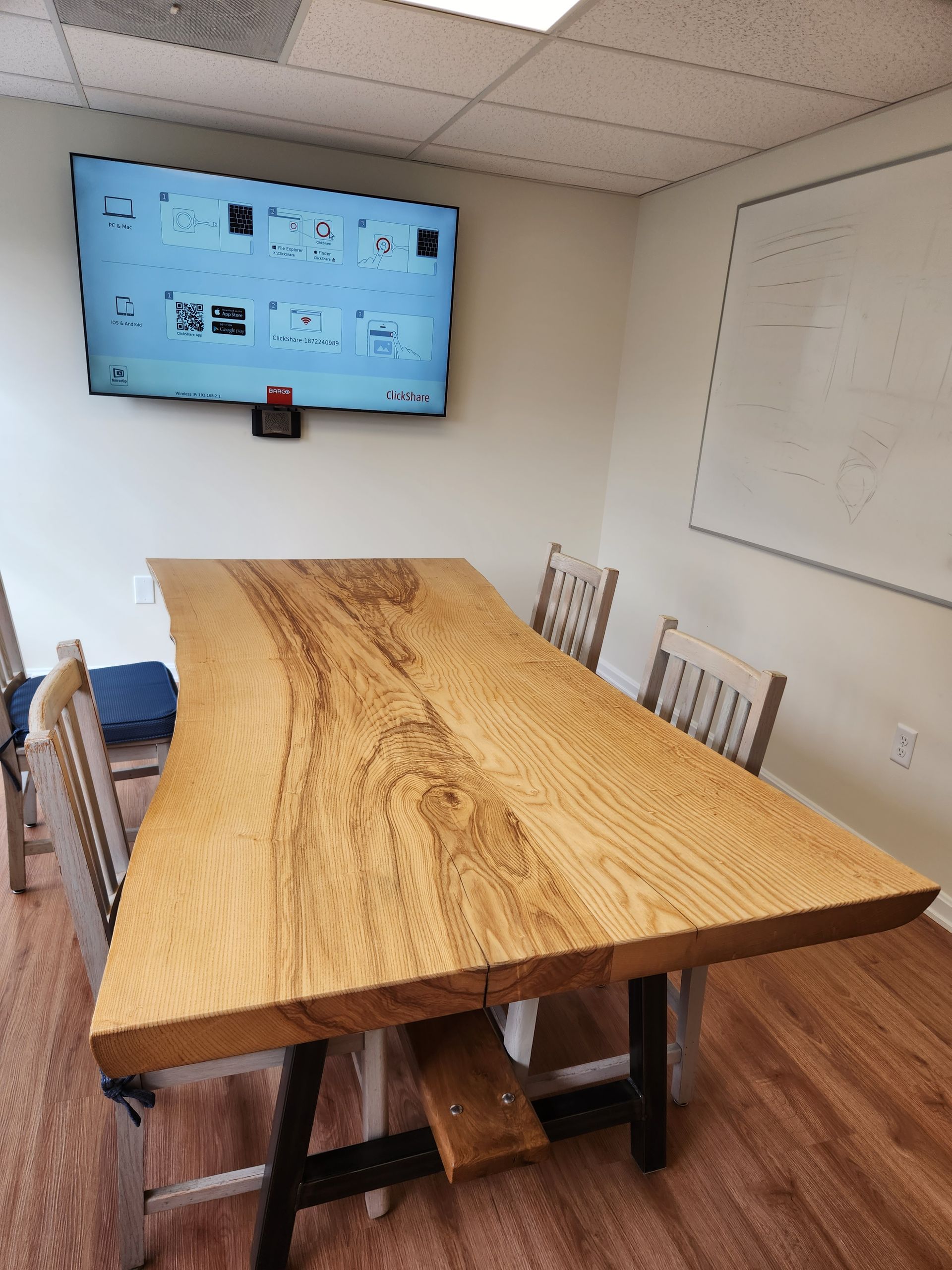 A conference room with a large wooden table and chairs