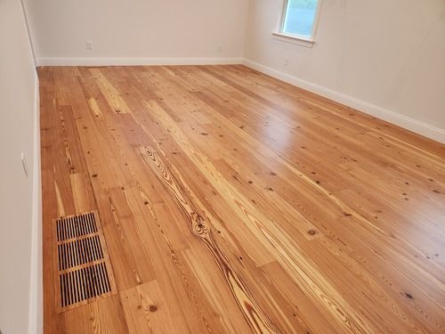 An empty room with hardwood floors and a window.