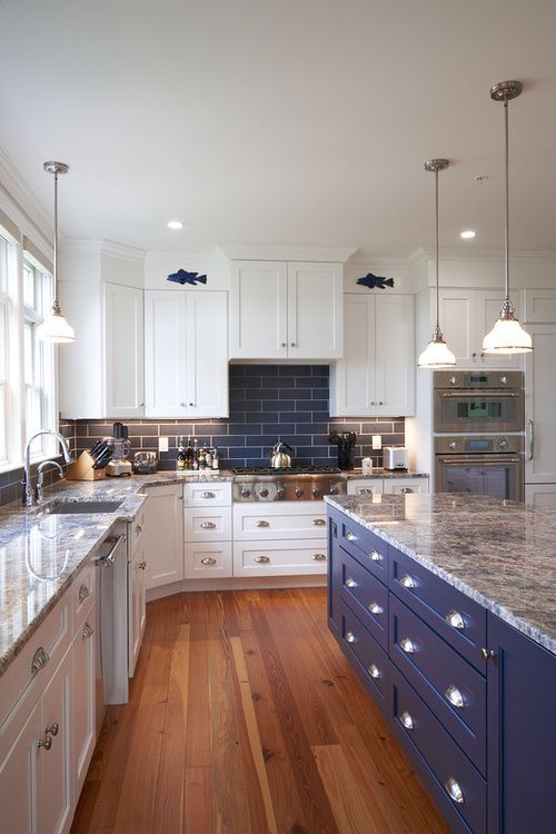 A kitchen with white cabinets and a blue island