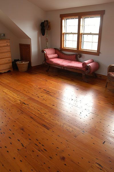 A living room with hardwood floors and a pink chaise lounge.