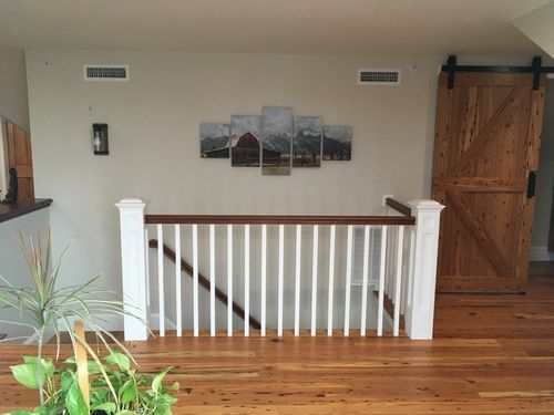 A wooden staircase with a white railing and a sliding barn door.