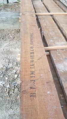 A stack of wooden boards sitting on top of each other on the ground.