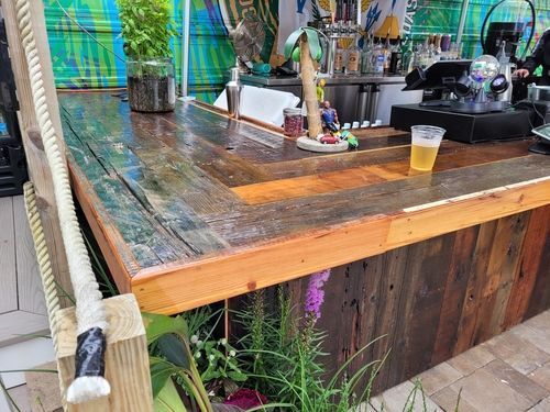 A wooden bar with a glass of beer on it.