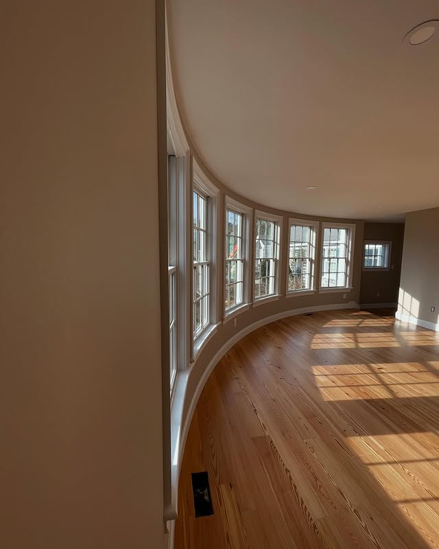 A room with a lot of windows and a wooden floor