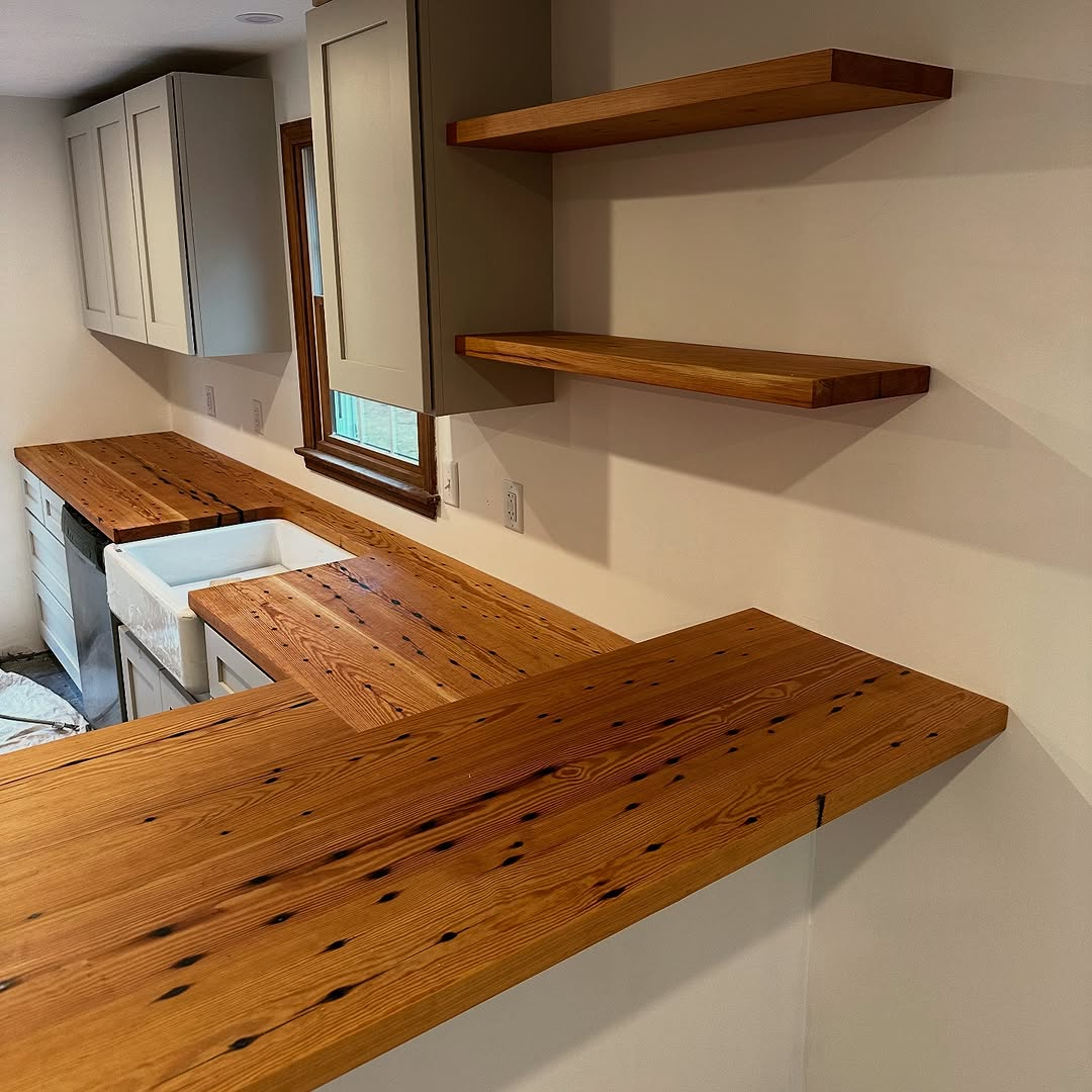 A kitchen with a wooden counter top and shelves