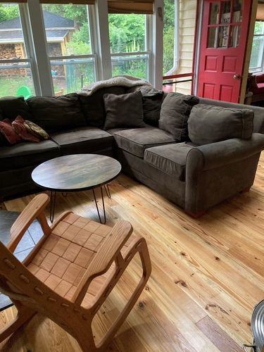 A living room with a couch , chair , table and rocking chair.