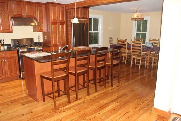 A kitchen with wooden cabinets and hardwood floors
