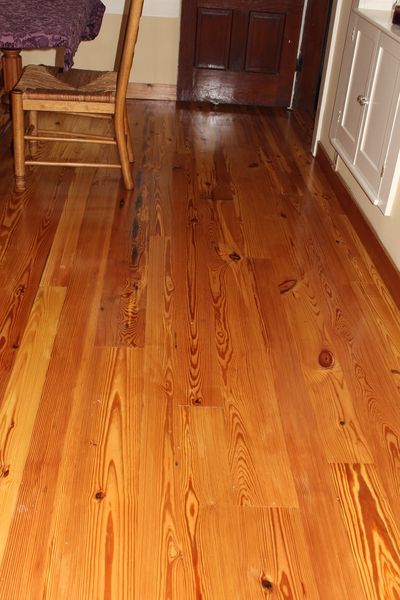 A wooden floor in a kitchen with a chair and a table.